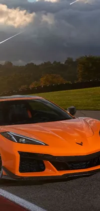 Upgrade your phone display with an energetic live wallpaper featuring a dynamic orange sports car in action