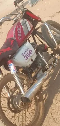 This live wallpaper features an eye-catching red and white motorcycle parked on a rugged dirt road