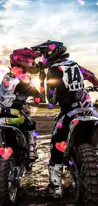 This animated live wallpaper depicts two dirt bikes next to each other, along with a romantic kissing picture in the background