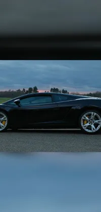 This sports car live wallpaper showcases a black Lamborghini parked on the side of a curvy road