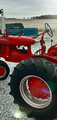 This live wallpaper depicts a red tractor on a gravel field, adding a rustic charm to your phone screen