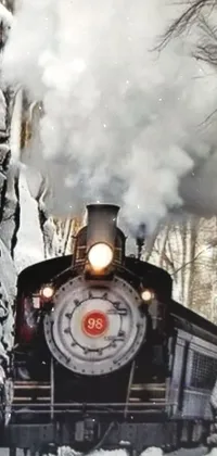 Transform your phone into a winter wonderland with this live wallpaper featuring a train chugging through a snow-kissed forest