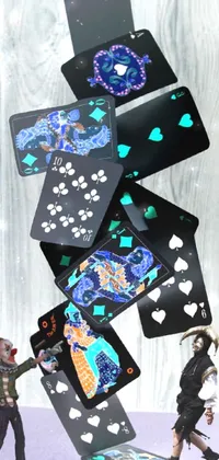 This live phone wallpaper features two figurines in the style of Uragami Gyokudō, shown throwing cards in the air against a black background