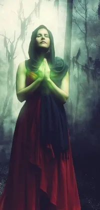 This phone live wallpaper depicts a mystical woman in a red dress standing in a green forest
