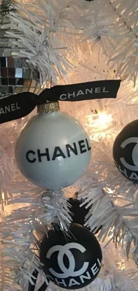 This live wallpaper for your phone showcases a close up of a dazzling Chanel ornament on a Christmas tree