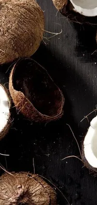 This phone live wallpaper features a high-contrast, grainy image of a still life with coconuts by Emanuel de Witte