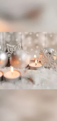 This live wallpaper for your phone features a group of candles flickering in a snowy landscape