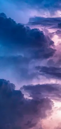 Looking for an unforgettable phone wallpaper? Look no further than this stunning design featuring a cluster of clouds floating across a deep blue and purple sky