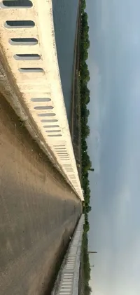 This phone live wallpaper features a stunning concrete art image of a bridge over water at eye-level as viewed by an iPhone camera