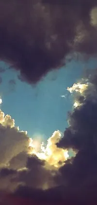 This stunning live mobile wallpaper features a heart made of cloud and sun rays that creates a dreamy and romantic atmosphere