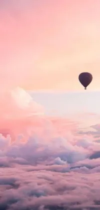 This phone live wallpaper showcases a stunning hot air balloon floating above fluffy clouds during a magical pink sunset