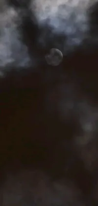 This live wallpaper features a mesmerizing sight of a full moon shining through the clouds