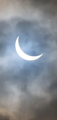 This phone live wallpaper depicts a partial solar eclipse in a cloudy sky