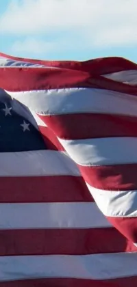 This live phone wallpaper features a closeup of a large American flag blowing in the wind