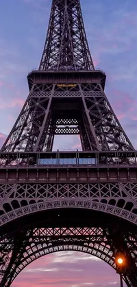 This phone live wallpaper depicts the Eiffel Tower glowing at dusk against a lilac sky