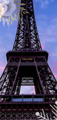 This live phone wallpaper features the Eiffel Tower in a violet and yellow sunset scene with surrounding snowflakes, perfect for iPhone 15 users