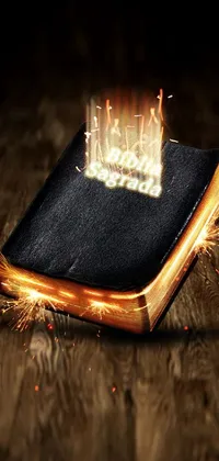 This phone live wallpaper showcases a striking digital rendering of a burning bible, set atop a wooden floor