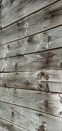 This phone live wallpaper features a visually stunning close up of a wooden wall with intricate rivets and white plank siding