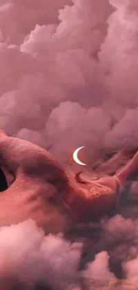 This live wallpaper features an animated hand reaching towards a crescent in the sky set against a surreal and dreamlike backdrop of pastel colors and cloudy reflections