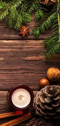 This stunning live phone wallpaper showcases a wooden table adorned with pine cones and a candle on a woodland background