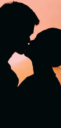 Elevate your phone's aesthetics with this beautiful live wallpaper of a romantic sunset kiss