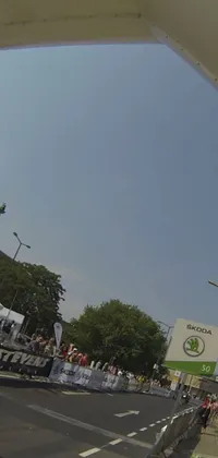 Get ready for an exhilarating phone live wallpaper featuring a truck driving down a busy street next to a towering building captured from a low-angle Go-Pro view