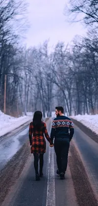Looking for a peaceful and intimate live wallpaper for your phone? Look no further than this winter-themed scene of two people walking hand-in-hand down a snowy road