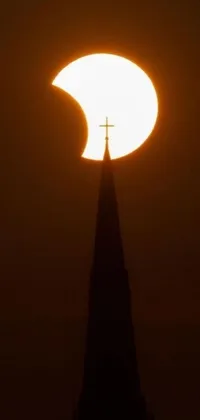 This stunning phone live wallpaper showcases a beautiful church spire with the golden sun setting behind it