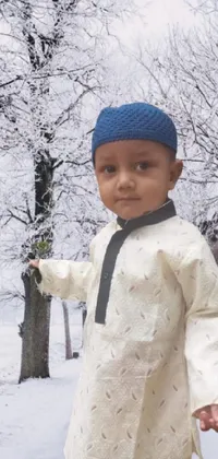 This live wallpaper depicts a charming little boy dressed in a jodhpuri suit and standing on the snow-covered ground