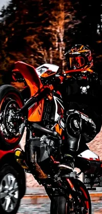 This intense phone live wallpaper features a skilled motorcyclist executing a daring trick, captured in a close-up pro photography shot with vibrant orange, red, black, and white hues