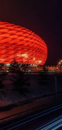 This live wallpaper portrays a striking red stadium lit up at night in Munich