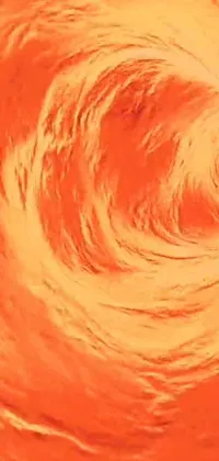 This phone live wallpaper depicts a surfing man riding a giant wave in an orange Color scheme
