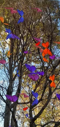 This beautiful phone live wallpaper features a colorful tree topped with several vibrant kites in sapphire butterfly jewelry hues, a perfect blend of digital art and pop art