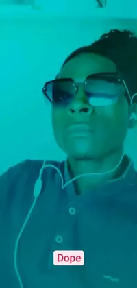 This live phone wallpaper features a close-up of a person wearing sunglasses, surrounded by Instagram, video art, and ambient teal light