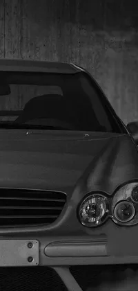 This black and white live wallpaper features a photorealistic full-face shot of a late 2000's Mercedes car