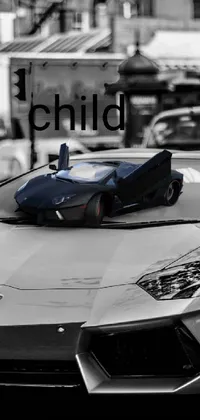 This phone live wallpaper features a bold black and white photograph of a sleek sports car in Lamborghini style against a backdrop of blue and gray tones
