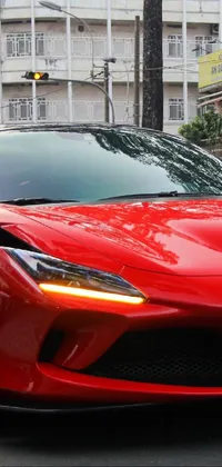 This phone live wallpaper showcases a high-powered red sports car driving through a bustling city street