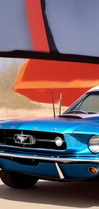 This stunning 4k live wallpaper features a blue vintage Mustang parked in front of a surfboard on a Moab beach