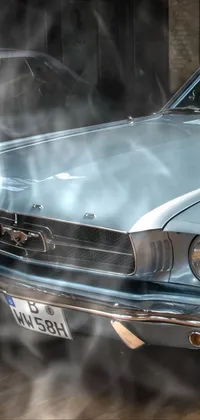 This live wallpaper for your phone features a blue mustang and a silver car, both parked in a showroom with the soft top roof of the blue mustang raised
