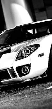 Looking for a sleek and stylish wallpaper for your phone? This HD live wallpaper features a black and white photograph of a sports car - the GT40
