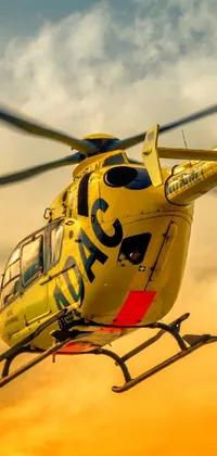 This phone live wallpaper showcases a yellow helicopter flying through a cloudy sky at dusk