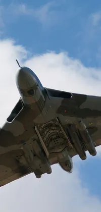 This phone live wallpaper features a breathtaking scene of a military jet soaring through the cloudy blue sky