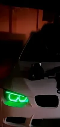 This phone live wallpaper depicts a mesmerizing scene of a car driving down a dark street at night
