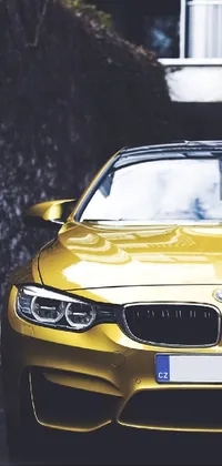 This phone live wallpaper showcases a shining yellow BMW car parked in front of a contemporary building