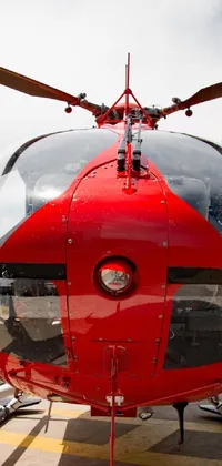 This stunning live wallpaper showcases a red helicopter sitting on an airport tarmac