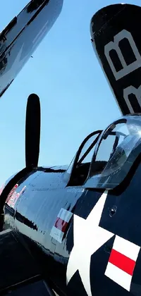 This phone live wallpaper depicts a propeller plane parked on a scenic airport tarmac