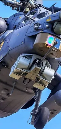 This phone live wallpaper features an impressive display of a military helicopter flying through a deep blue sky