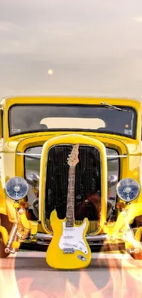 Rev up your phone's style with this energetic live wallpaper! This 4k vertical wallpaper features a yellow Ford Model T with a guitar resting on the hood, perfect for any music lover or vintage car enthusiast