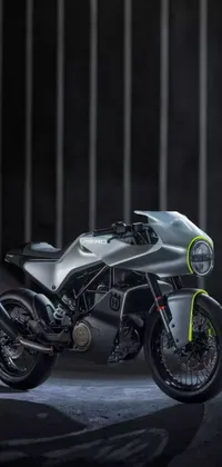 This phone live wallpaper features a digital rendering of a silver motorcycle parked inside a dark room