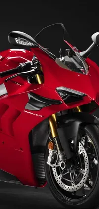 This stunning live wallpaper features a close-up view of a bold and powerful red Ducati Panigale motorbike, parked in front of a sleek black background